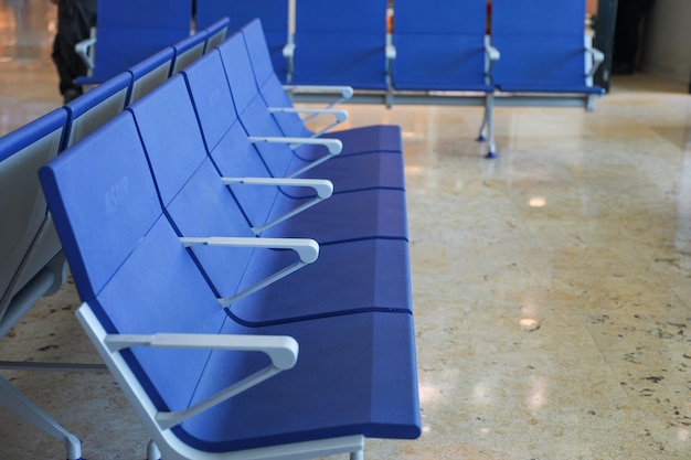 A row of blue chairs in a waiting room