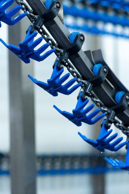 A row of blue plastic chains are on a conveyor belt.