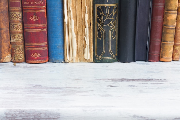 Row of books on white wooden desktop