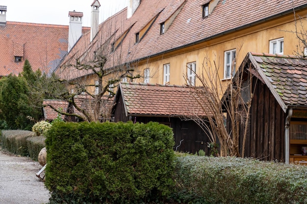 A row of brown houses with red roofs and white windows