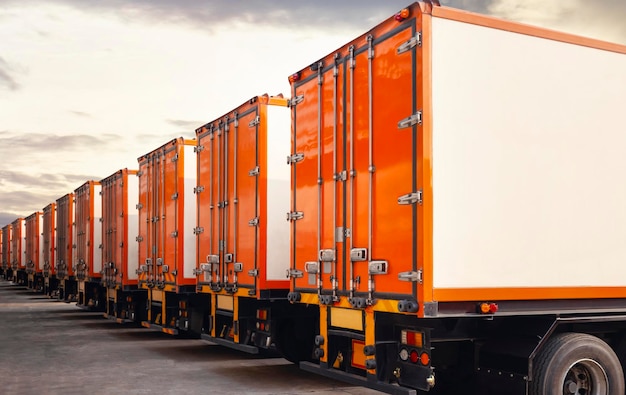 Ряд грузовых контейнеров Грузовики на стоянке с закатным небом Доставка грузовых контейнеров Логистика