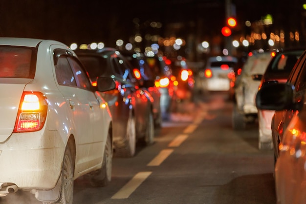 Row of cars stopped in front of traffic light at night