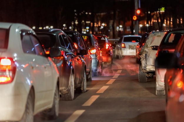 Row of cars stopped in front of traffic light at night