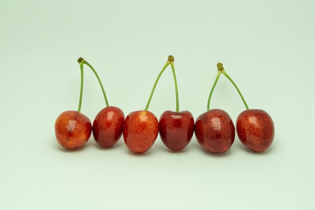 Foto una fila di ciliegie con il gambo è rossa.