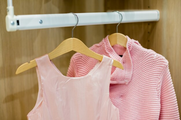 A row of children clothes hanging on hangers.