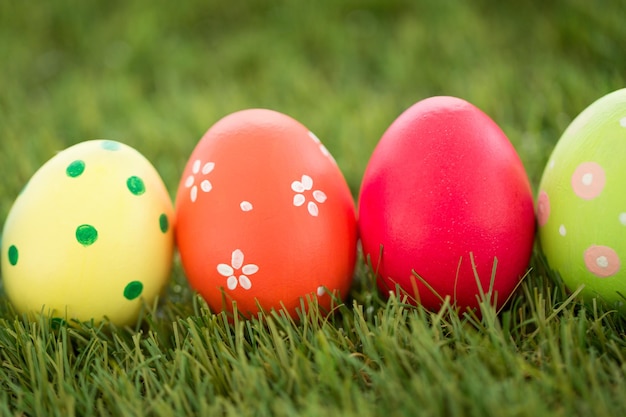 row of colored easter eggs on artificial grass