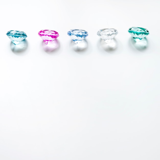 Row of colorful diamonds with shadow on white background