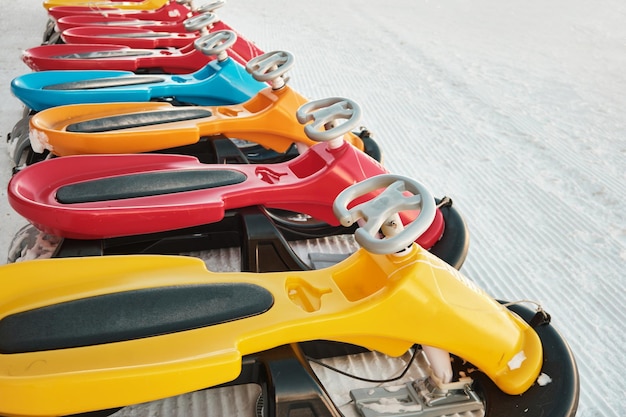 Row of colorful sleds to rent at ski resort snow sleighs winter leisure activities