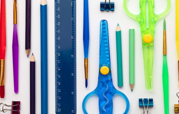 Row of colourful art supplies arranged in a rainbow