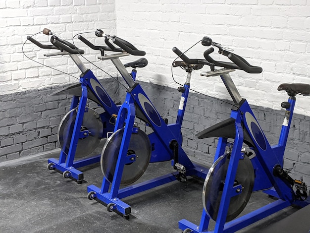 Photo row of cycling bicycle training machines in gym