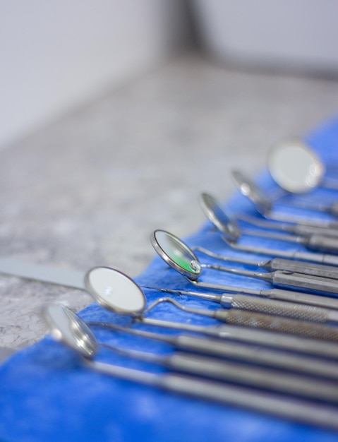 테이블 위에 파란색 천이 있는 치과 도구 한 줄.