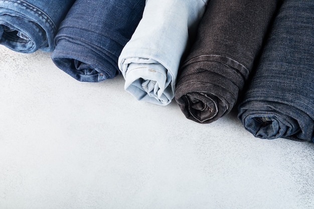 Premium Photo | Row of different rolled jeans on white background