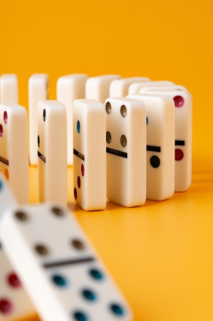 Row of domino tiles on yellow studio background