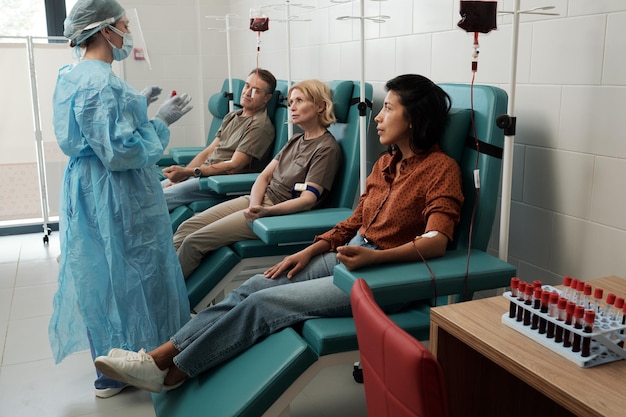 Row of donors sitting in hospital ward during hemotransfusion procedure