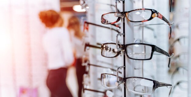 Row of glasses at an opticians Eyeglasses shop Stand with glasses in the store of optics Showcase with spectacles in modern ophthalmic store Closeup