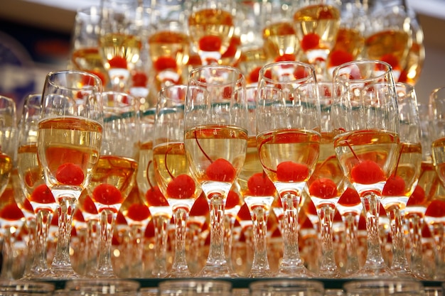 A row of glasses with champagne and cherries inside at the event.