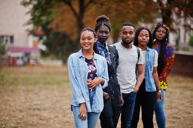 Photo row of group five african college students spending time together on campus at university yard black afro friends studying education theme