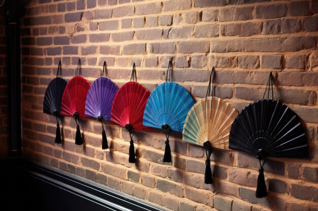 Photo a row of hand fans hanging on a line against a brick wall