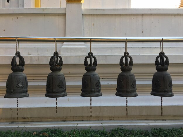 Photo row of lanterns hanging on railing against wall