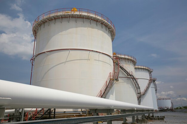 Row of large white tanks for petrol pipeline oil and gas