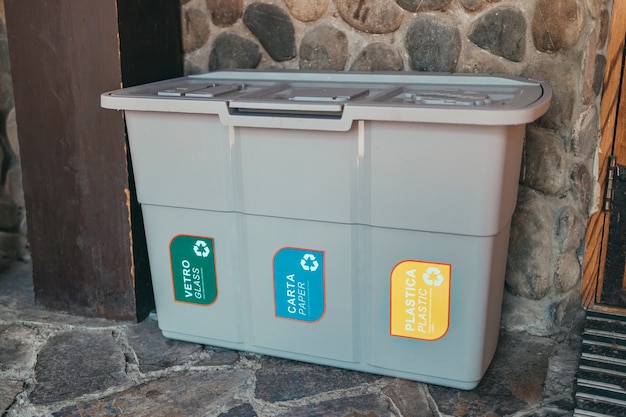 Row of many different multicolored plastic waste cans for garbage sorting and recycling at city stre...