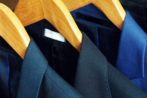 Row of mens suits hanging in closet