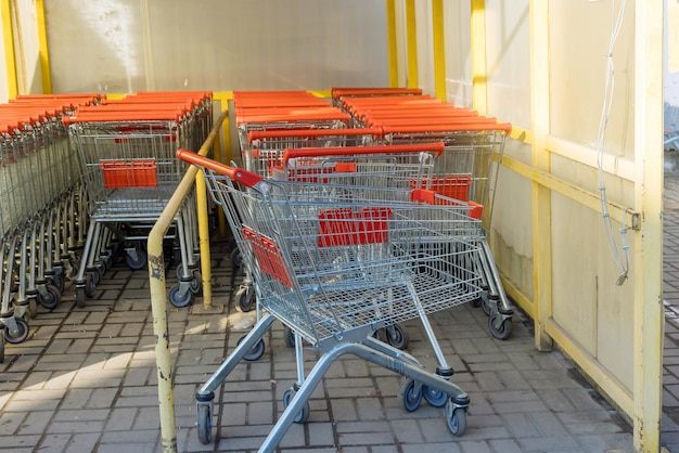 A row of metal carts near a shopping center are placed in a row in a hypermarket