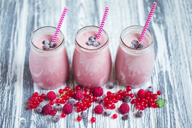 Row of milkshake jars with berries aside