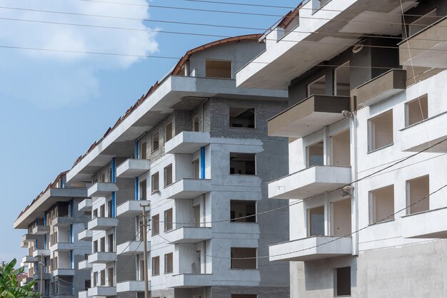 A row of monolithic freshly built residential buildings against the sky