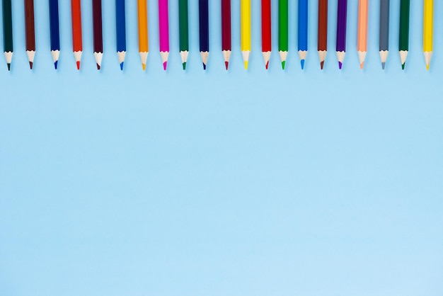 A row of multicolored pencils on a blue background Back to school concept