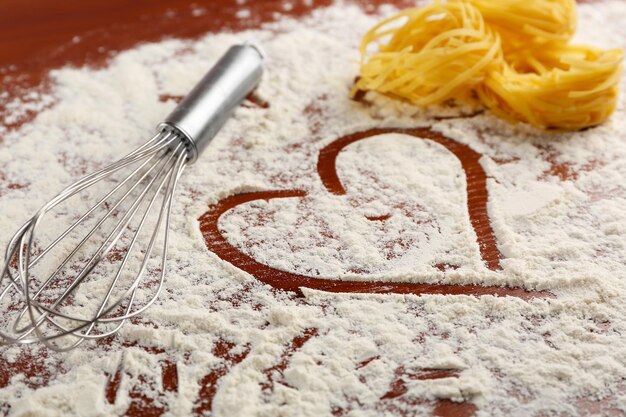 Row pasta with corolla on flour background