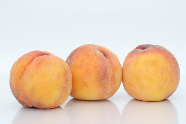 A row of peaches on a white background