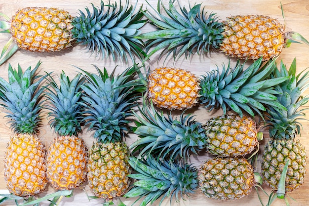 Row of pineapple on wooden table background