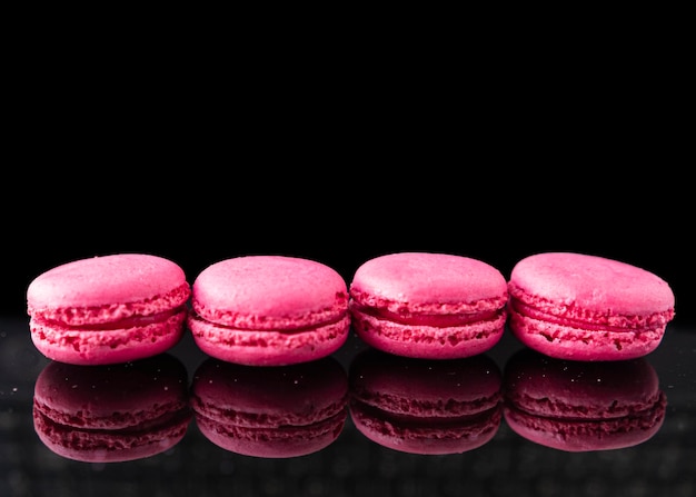 A row of pink macaroons with the word macaroons on the bottom