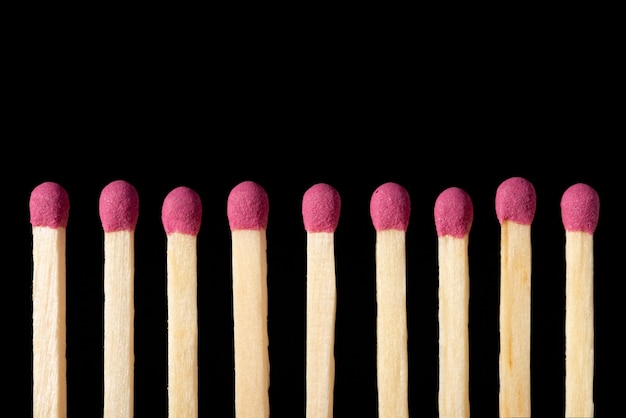 Row of pink matches on a black  close up