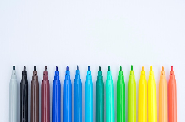 A row of rainbow colored crayons are lined up in rows.