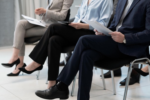 Row of several company employees in formalwear sitting at conference