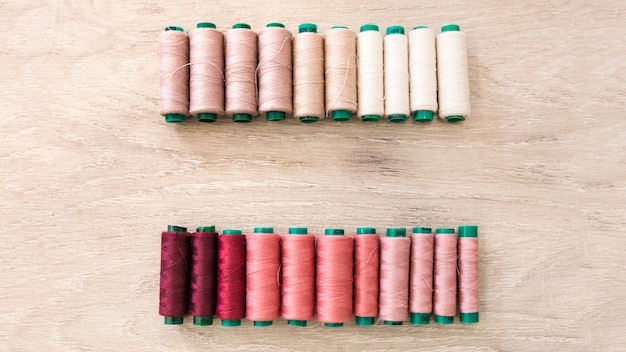 Row of spools on wooden surface