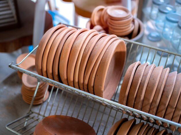 Row of terracotta dishes on old stainless steel shelf