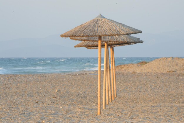 Una fila di ombrelloni di paglia sulla spiaggia contro il cielo