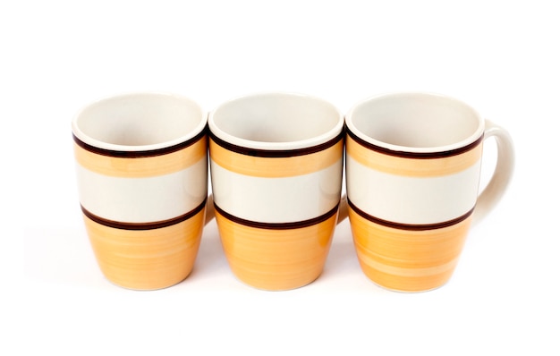 Row of three mugs isolated on white surface