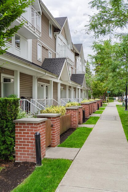 Photo row of townhouses with concrete pathway in front on couldy day in vancouver bc