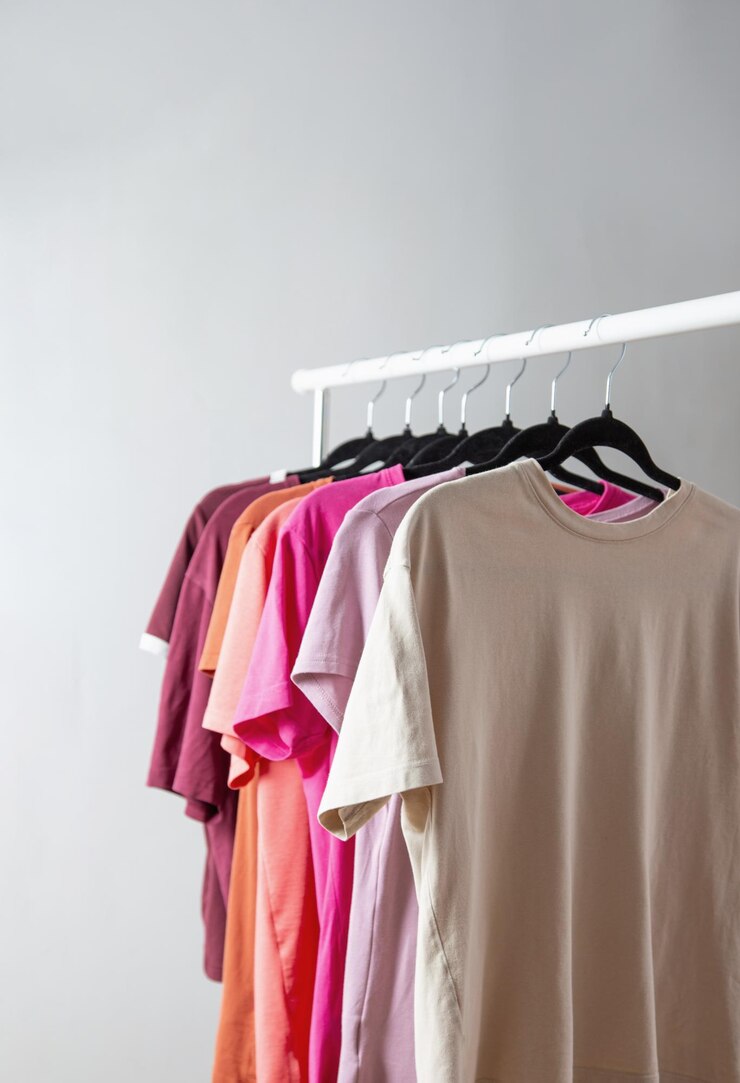 row of tshirts on a hanger against a background of a white wall hanger