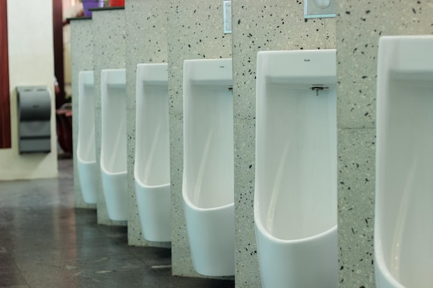 A row of urinals with one of them labeled'urinals '