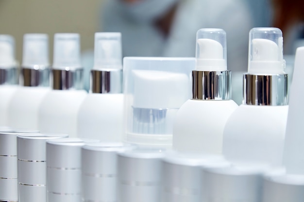 Row of white blank bottles with cosmetic products