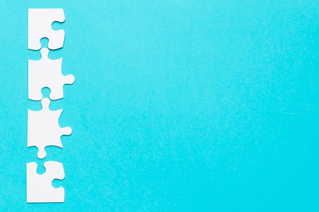 Row of white jigsaw puzzle on blue backdrop