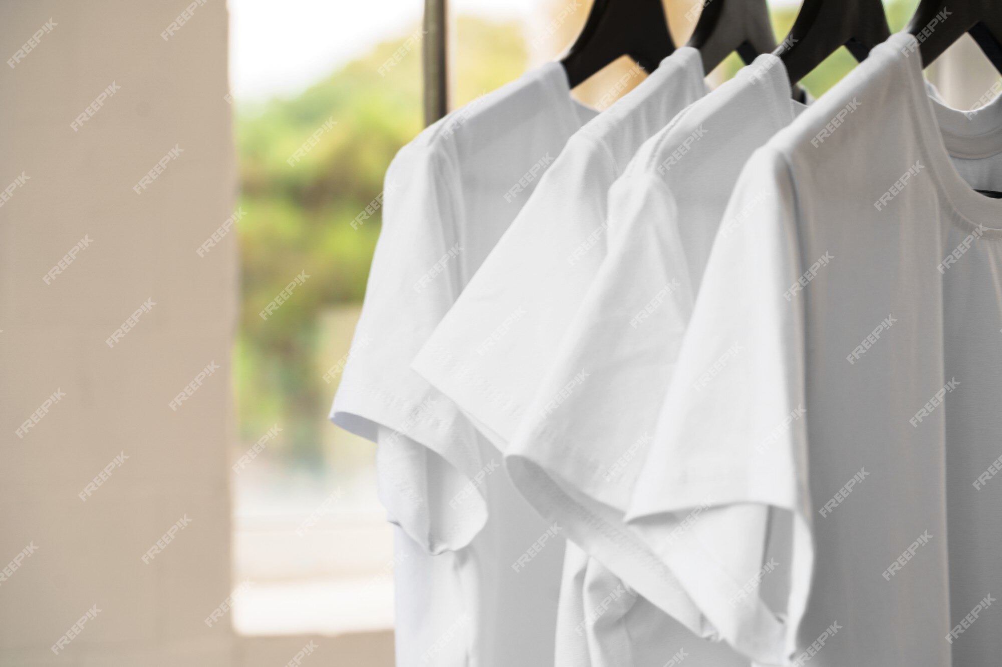 Row of black and white t-shirts hanging on rack Stock Photo by FabrikaPhoto