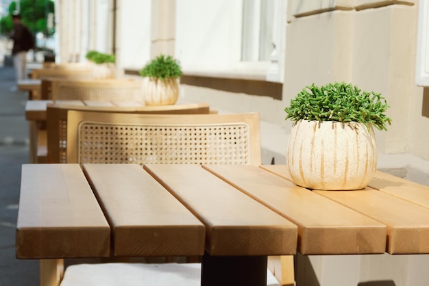 row of wooden tables and chairs at the entrance to the cafe Summer veranda with empty tables decora