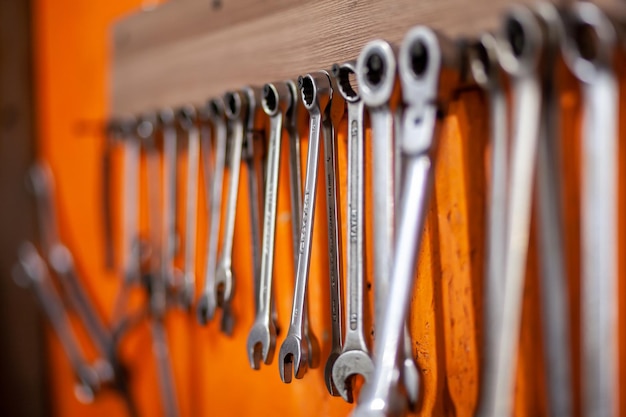 A row of wrenches hang from a wall.