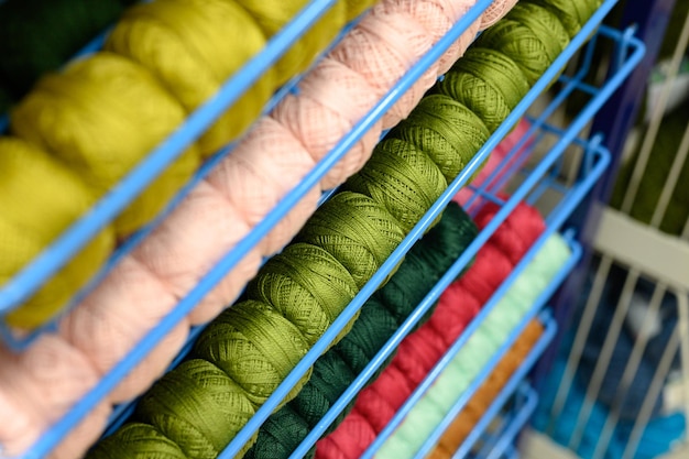 Foto raggi di palle di colorati fili di filato di cotone per la maglieria di colori rosa pallido e verde sugli scaffali